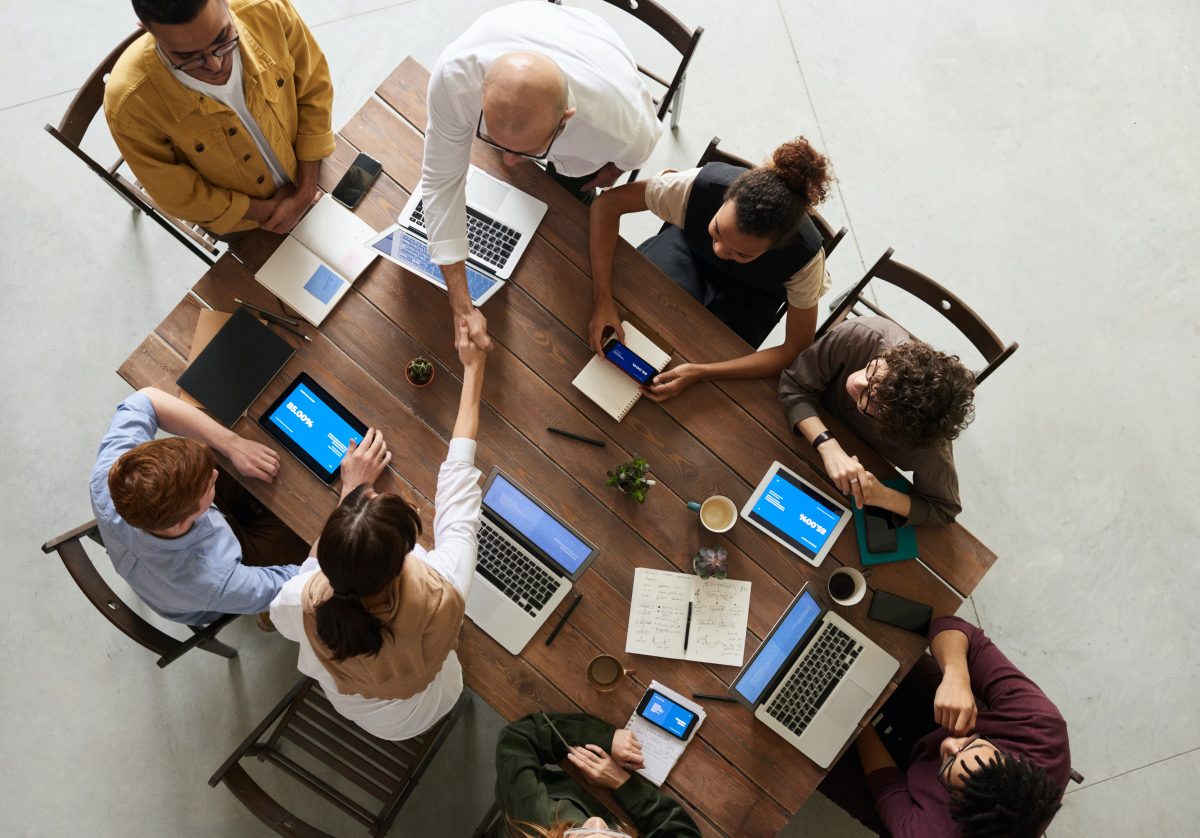 Stock image of team collaboration at desk with laptops